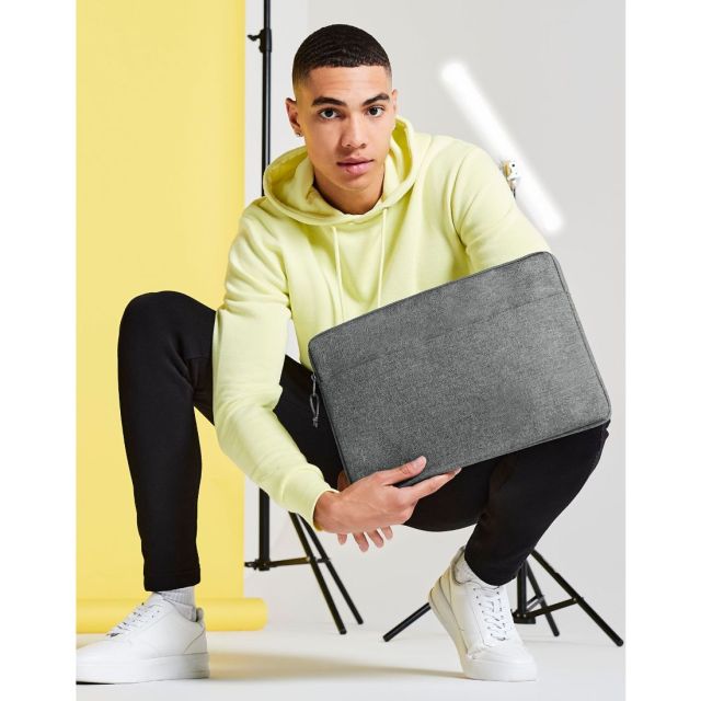 A man holding the Bagbase Essential 15" Laptop Case in Grey Marl