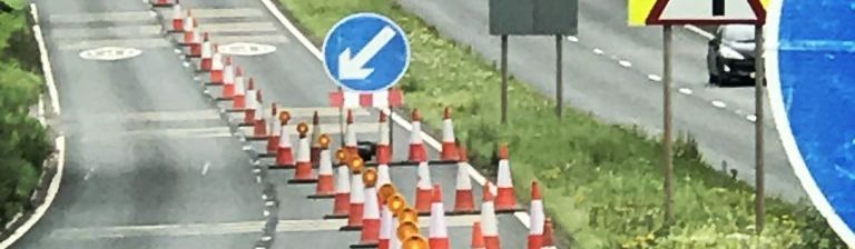 Image shows signs to control traffic for road workers