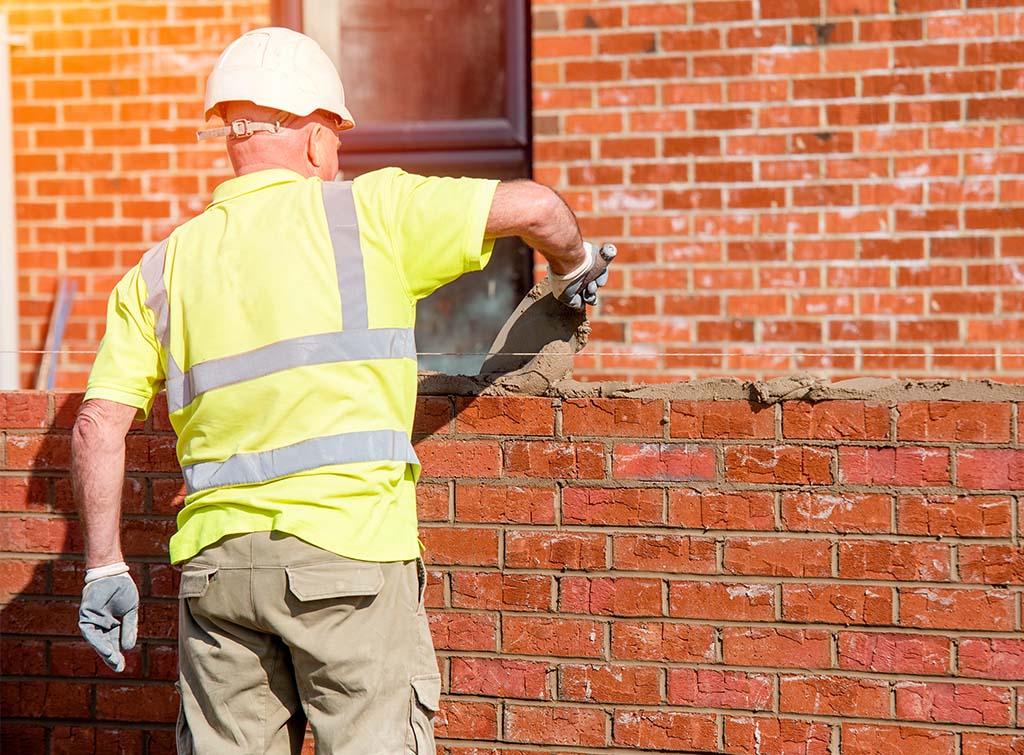 Man laying bricks on a construction site